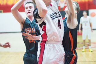 Marcus Larson/News-Register##McMinnville senior guard Cameron Fox (4) puts up a shot between two Sprague defenders in the Grizzlies’ 49-47 victory over the Olympians Tuesday night at The Furnace. Fox scored one point in the contest, his first appearance of the season. Marcus Larson/News-Register##McMinnville senior guard Cameron Fox (4) puts up a shot between two Sprague defenders in the Grizzlies’ 49-47 victory over the Olympians Tuesday night at The Furnace. Fox scored one point in the contest, his first appearance of the season.