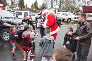 Starla Pointer / News-Register##
Handing out stuffed toys and candy at the basketball practice are Carlton police Chief Kevin Martinez, Mayor-elect Brian Rake, Special Officer Santa, Officer Tim Jordan and volunteer Lucas Meeker.